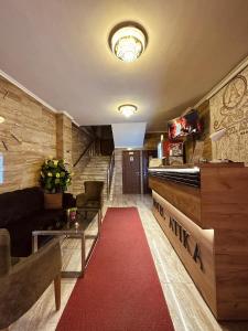 斯科普里Motel Atika的客厅铺有红地毯,配有沙发