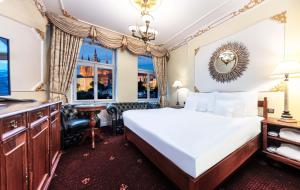 布拉格Hotel General Old Town Prague的一间卧室配有一张床、一张书桌和一个窗户。