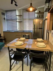 贝洛奥里藏特LOFTS CARIJOS CENTRO BH的厨房配有桌椅和冰箱。