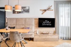 湖城Exklusiv und elegantes Apartment in der Residenz Silvretta inkl Silvretta Premium Summer Card的一间带木桌和椅子的用餐室