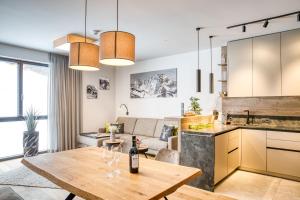 湖城Exklusiv und elegantes Apartment in der Residenz Silvretta inkl Silvretta Premium Summer Card的厨房以及带酒杯桌子的客厅。