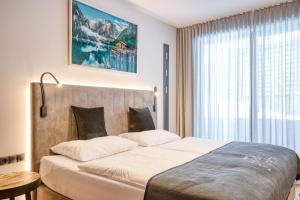 湖城Exklusiv und elegantes Apartment in der Residenz Silvretta inkl Silvretta Premium Summer Card的一间卧室设有一张大床和一个大窗户