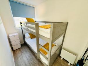桑当2 Bedroom Chalet SB22, Sandown Bay, Isle of Wight, Dog Friendly的小型客房设有一张双层床,配有窗户