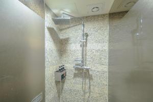 西归浦市From H Oceanpalace Hotel Jeju的带淋浴的浴室,带玻璃门