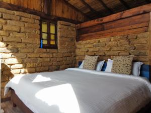 瓜塔维塔Cabaña Isla Dorada的卧室配有砖墙内的床铺