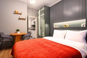 伊斯坦布尔TAKS-INN Suites的一间卧室配有一张带红色毯子和桌子的床。