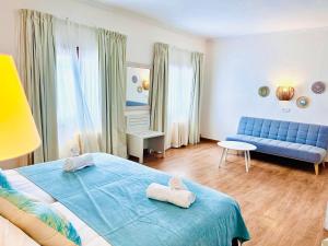 索列尔港米拉马尔酒店的一间卧室配有蓝色的床和蓝色的沙发