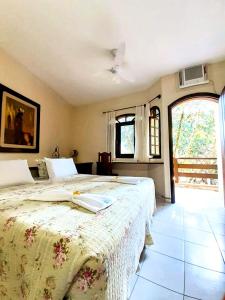 瓜鲁雅Pousada e SPA Canto do Mar的一间卧室设有两张床和大窗户