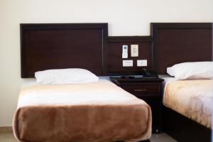 沙姆沙伊赫Sharks Bay Oasis Resort & Butterfly Diving Center的酒店客房带两张床和电话