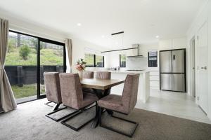 汉密尔顿Stunning 3 bedrooms house in Hillcrest - Close to Waikato University & Cambridge的厨房以及带木桌和椅子的用餐室。