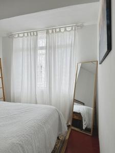 莎阿南The Classy RomaAkar的卧室配有白色的床和镜子