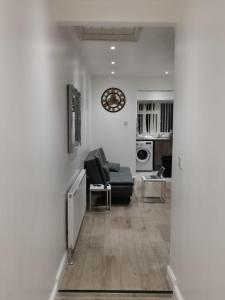 卢顿Three Bedroom Modern Apartment by Luton Airport and Luton Station的客厅配有沙发和墙上的时钟