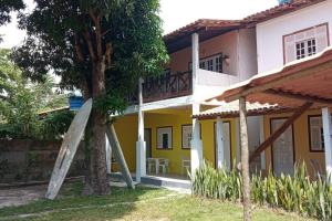 库穆鲁沙蒂巴Suíte em Cumuruxatiba beira-mar的黄白色的房子,有树和梯子
