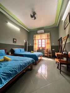 Ðông Tác (1)Trại Hoa Vàng Homestay at Tuy Hòa Phú Yên的一间卧室设有两张床和窗户。
