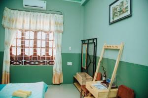 Ðông Tác (1)Trại Hoa Vàng Homestay at Tuy Hòa Phú Yên的一间卧室配有一张床、一个窗口和一张书桌