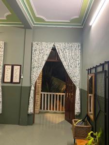 Ðông Tác (1)Trại Hoa Vàng Homestay at Tuy Hòa Phú Yên的一间设有门的房间和一个带窗帘的窗户