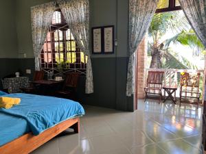 Ðông Tác (1)Trại Hoa Vàng Homestay at Tuy Hòa Phú Yên的一间卧室设有一张床和一个大窗户