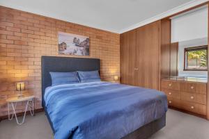 伊登伊登海滩休闲度假酒店的一间卧室设有蓝色的床和砖墙