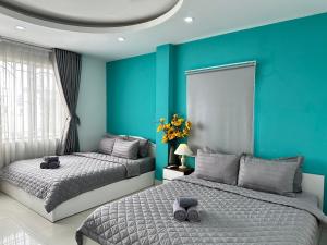 胡志明市Thắng Hà Hotel的卧室设有两张床铺和蓝色的墙壁
