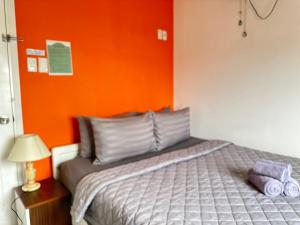 胡志明市Thắng Hà Hotel的一间卧室配有一张橙色墙壁的床