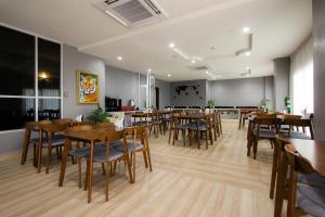 乔木提恩海滩Valhalla Pattaya的用餐室配有木桌和椅子