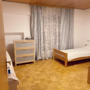 NiedensteinFamilienhaus的一间卧室配有一张床、一个梳妆台和一扇窗户。
