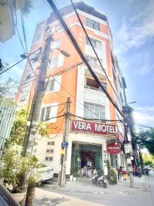 河内Vera Hotel Hà Nội的前面有 ⁇ 翠汽车旅馆标志的高楼
