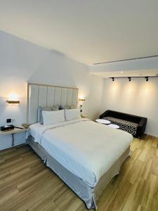 大园区TY精品商务旅馆的卧室配有一张白色的大床,铺有木地板