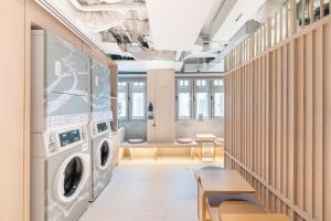 新加坡Jyu Capsule Hotel的洗衣房配有洗衣机和烘干机