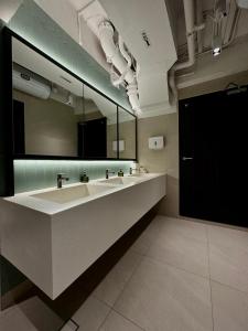 新加坡Jyu Capsule Hotel的一间带水槽和大镜子的浴室