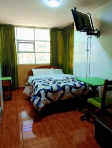 万卡约Sierra Verde - Muy Céntrico Hs的一间卧室配有一张床和一台平面电视