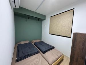 Kampong PendasIskandar Puteri Sunway Grid Residence Deluxe Loft by Ningle Loft的卧室配有两张床和墙上的屏幕