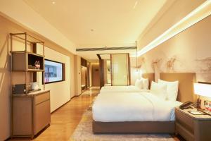 广州琶洲岭南东方酒店的酒店客房设有一张大床和一台电视。