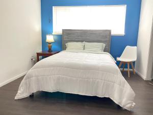 长滩Modern Stay - Private Room的一间卧室配有一张带白色床罩的床和窗户。