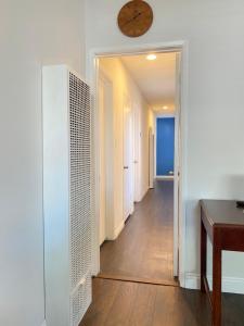 长滩Modern Stay - Private Room的一间墙上挂有时钟的走廊客房