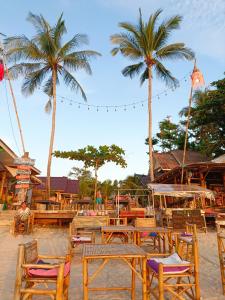 高兰海贝壳海滩度假村 的棕榈树海滩上的一组桌椅