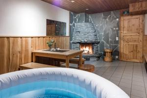 库萨莫Hotel Kuusamon Portti的带壁炉的客房内的热水浴池