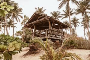 CatangnanALON CLOUD9, beach front的棕榈树海滩上的竹屋