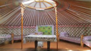 TsalgarKhyargas Khuh Bukh的配有长凳和桌子的蒙古包的客房