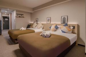 大阪Apartment Hotel 11 Namba Minami III的酒店客房,配有两张带毛巾的床