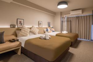 大阪Apartment Hotel 11 Namba Minami III的酒店客房,设有两张床和一张沙发
