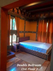 普纳卡Nobgang B&B "Traditional Heritage HomeStay"的一间设有床铺的卧室,位于带窗户的房间内