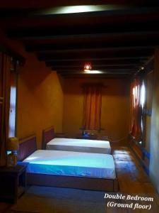 普纳卡Nobgang B&B "Traditional Heritage HomeStay"的一张大床,位于一个红色窗帘的房间