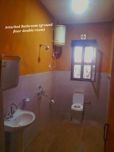 普纳卡Nobgang B&B (Restaurant and Lodge)的一间带水槽和卫生间的浴室以及窗户。