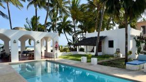 MsambweniSawa Sawa Beach House的一座别墅,设有游泳池和棕榈树