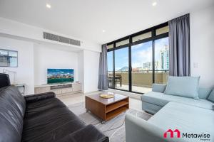 悉尼MetaWise Sydney CBD Haymarket Luxe 2Bed Penthouse Bella的带沙发和电视的客厅