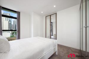 悉尼MetaWise Sydney CBD Haymarket Luxe 2Bed Penthouse Bella的白色的卧室设有白色的床和窗户。