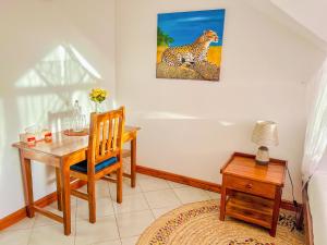 阿鲁沙Heart of Africa Lodge的用餐室配有书桌,墙上挂有猎豹画