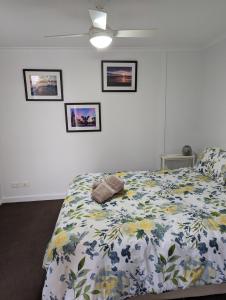 格莱内尔格The Heart of Glenelg的一间卧室配有一张带花卉棉被的床
