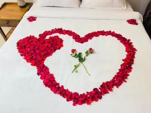 阿鲁沙Heart of Africa Lodge的床上红花制成的心